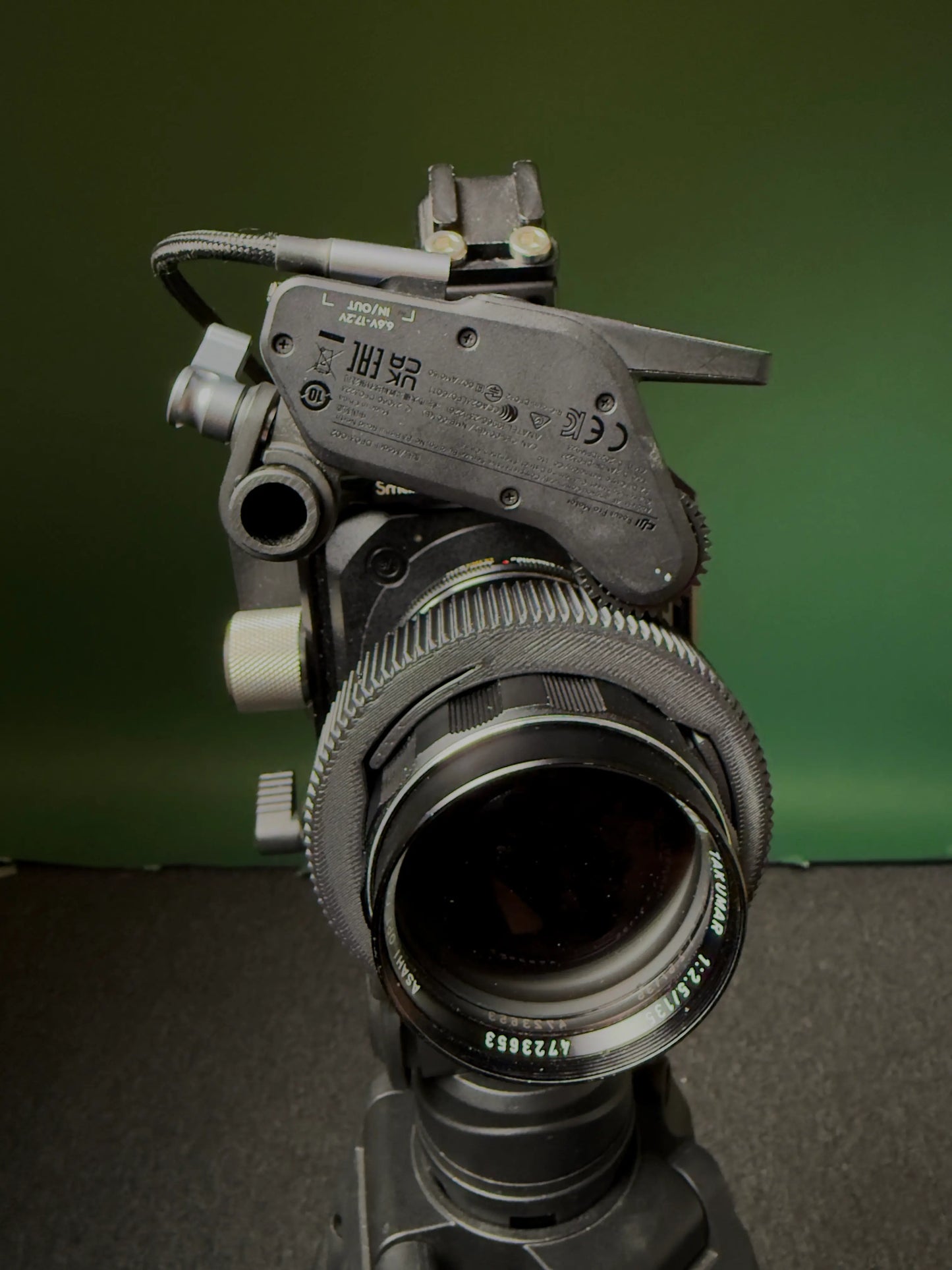 Super Takumar 135mm Linse mit einem Follow focus Ring und einem follow focus Motor installiert vor grünem Hintergrund