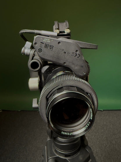 Super Takumar 135mm Linse mit einem Follow focus Ring und einem follow focus Motor installiert vor grünem Hintergrund