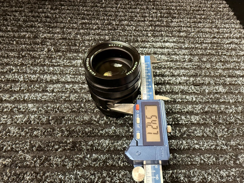 eine Voigtleander Linse wird mit einem Messschieber vermessen