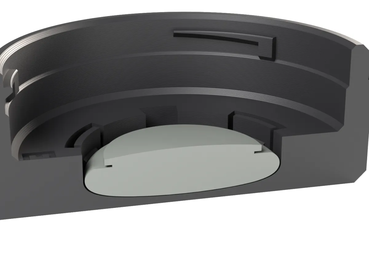 Cut through the Canon EF AirTag rear cap: the AirTag held by snap tabs below the lens room